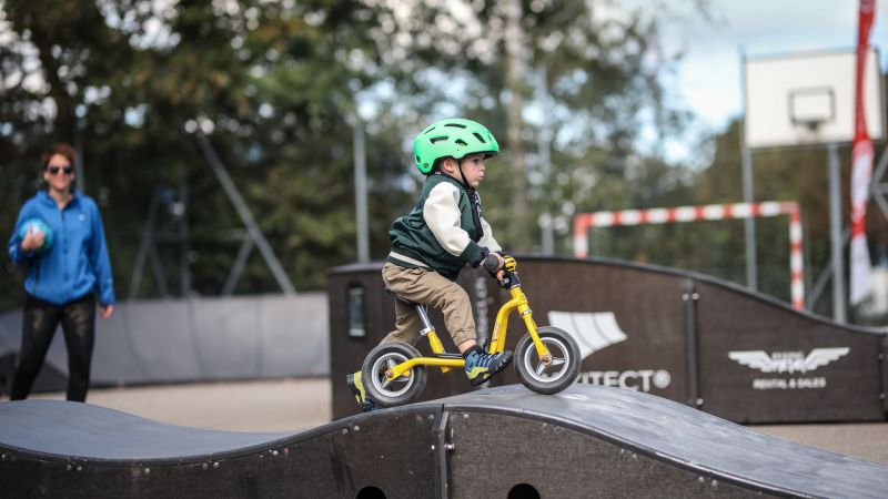 Ein kleiner Junge fährt über einen Pump-Track